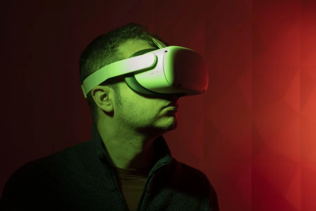 Serious man with white virtual reality goggles with red background and side green light